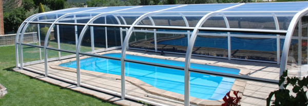 Abri de piscine Ibiza installé à Chalamont près de Bourg-en-Bresse (01). Appui sur un mur, ouverture centrale et panneaux relevables.