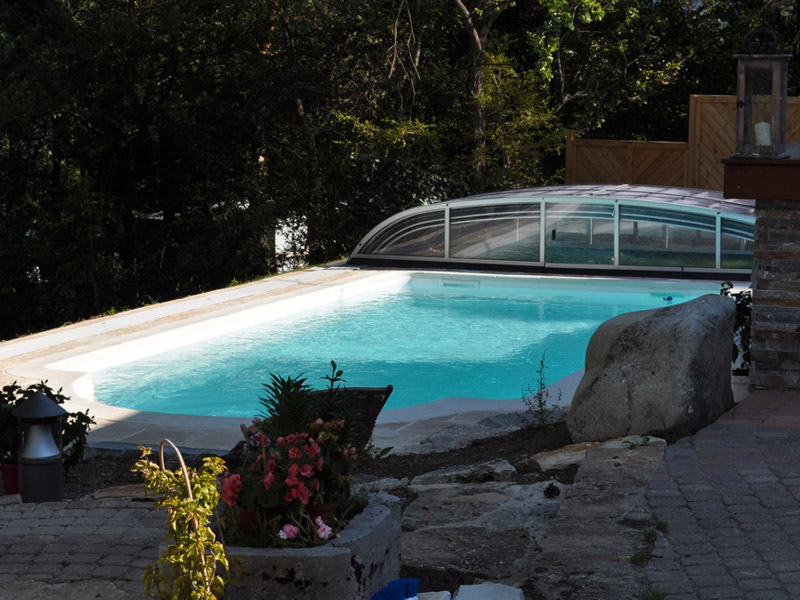 Abri de piscine bas entièrement transparent installé en région montagneuse à Monestier-de-Clermont près de Grenoble.
