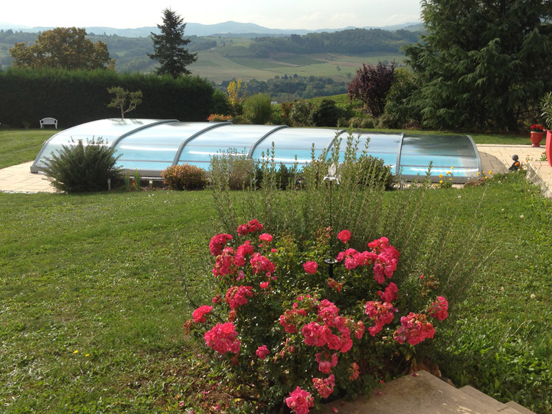 Abri de piscine bas en forme d'anse de panier, télescopique, sur roulette sans rail au sol, intallée dans la vallée d'Azergues (69)