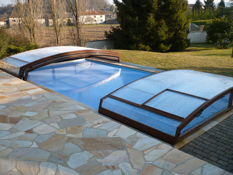 Abri de piscine bas modèle Chypre coulissant avec guidage sur un seul côté, ouverture possible sur les 2 côtés, central ou intégralement. Installé à l'Isle d'Abeau (38)
