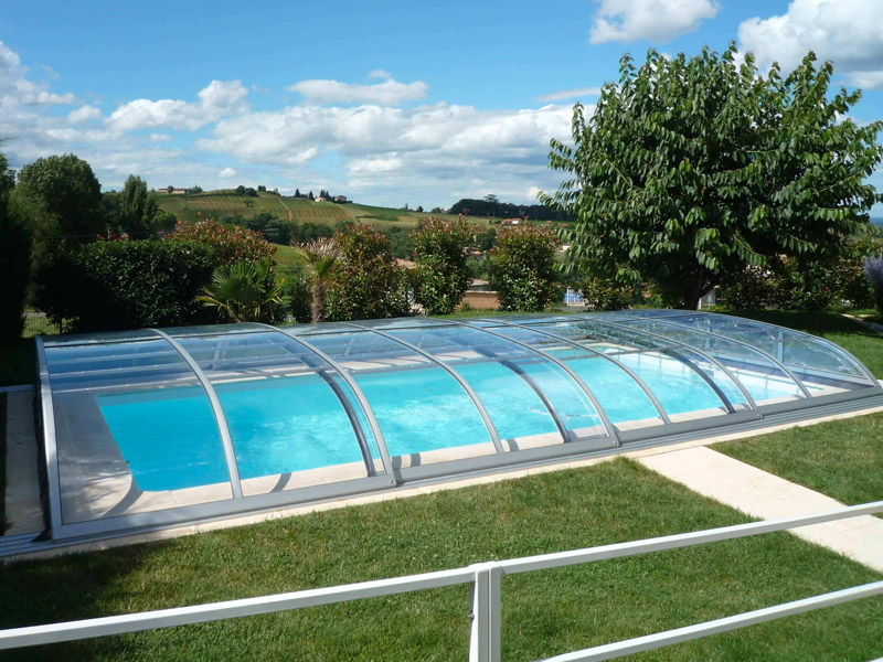 Abri de piscine modèle Baléares panoramique et téléscopique avec 2 guides au sol, installé à Anse près de Villefranche dans le Beaujolais.