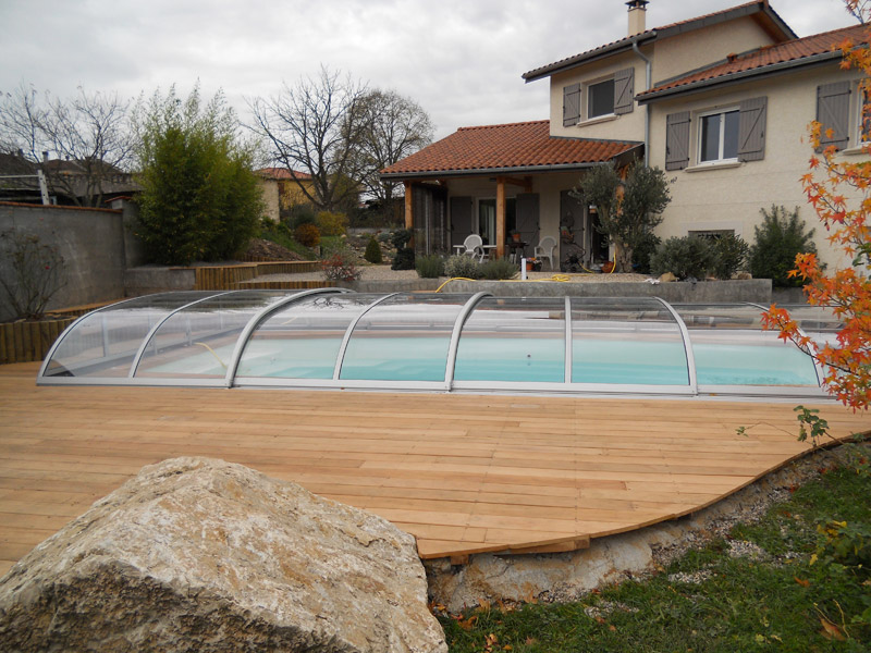 Abris de picspiscinecine Modèle Baléares entièrement transparent et téléscopique avec terrasse bois, installé à La Verpillière (Isère)
